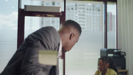 African-american-business-man-using-sticky-notes-brainstorming-problem-solving-strategy-on-glass-whiteboard-leader-man-showing-solution-for-project-deadline-in-office.