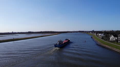 Barco-Mercante-Que-Viaja-A-Través-Del-Río-Noord-Pasando-Por-La-Ciudad-De-Hendrik-ido-ambacht-En-Holanda-Del-Sur,-Países-Bajos