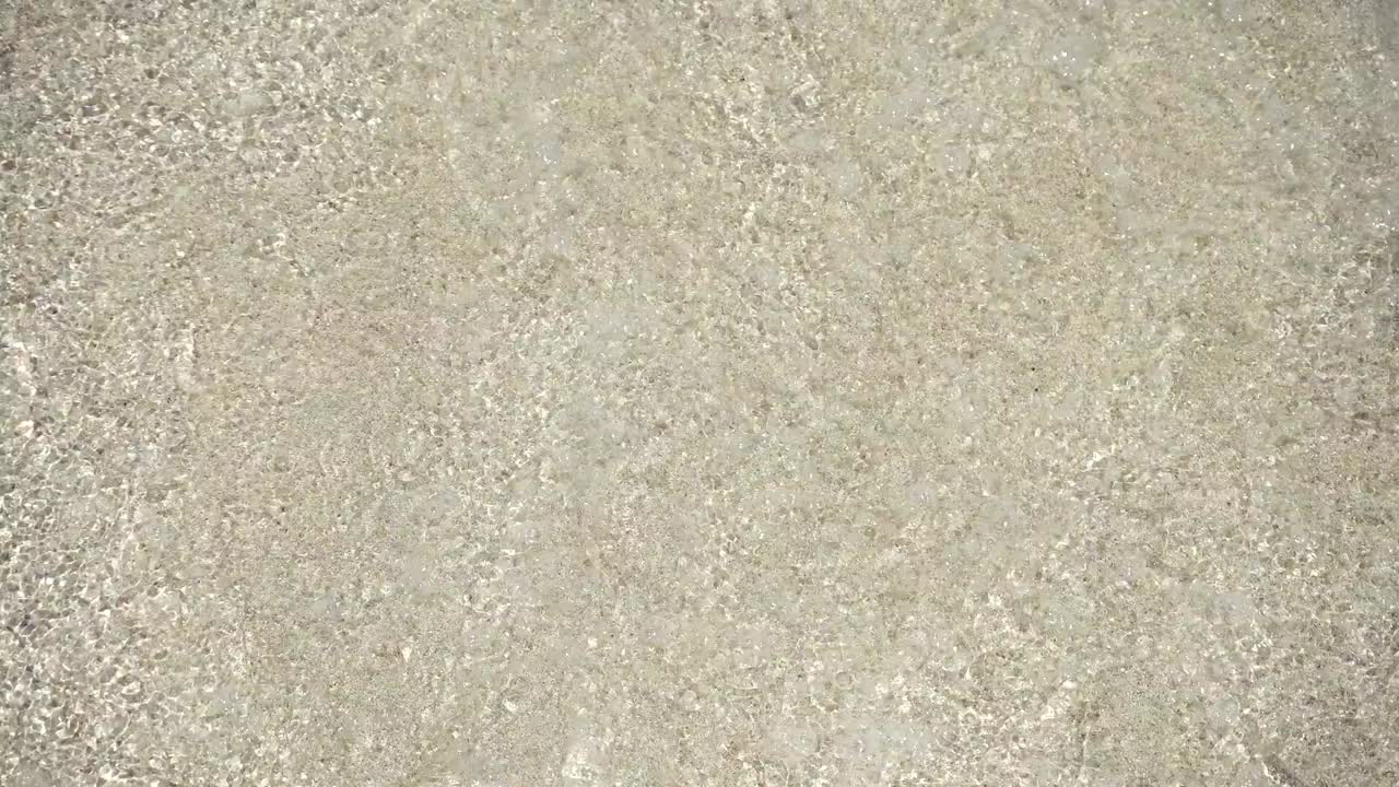 mujer extendiendo protector solar en su brazo en la playa en un caluroso día soleado