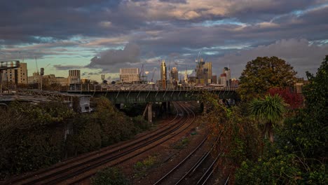 Zeitraffer-Von-Intercity-Zügen-Vor-Londoner-Wolkenkratzern-Bei-Sonnenuntergang