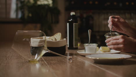 preparing an appetizer with bread, olive oil, and mustard