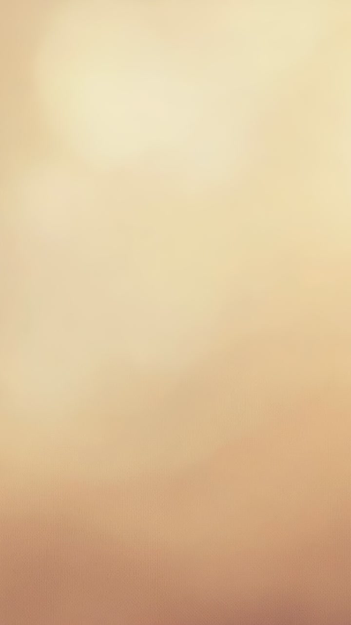 Vertical video: Starting warm glowing bokeh orbs drifting across beige gold gradient for backdrop