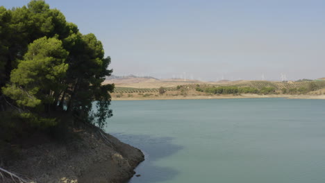 pine trees and wind turbines on shores of lake caminito del rey,spain