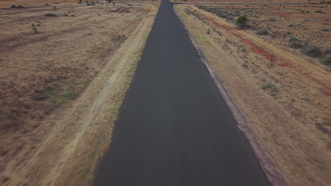 Ripresa cinematografica 4K con drone di una strada nella boscaglia australiana (2)