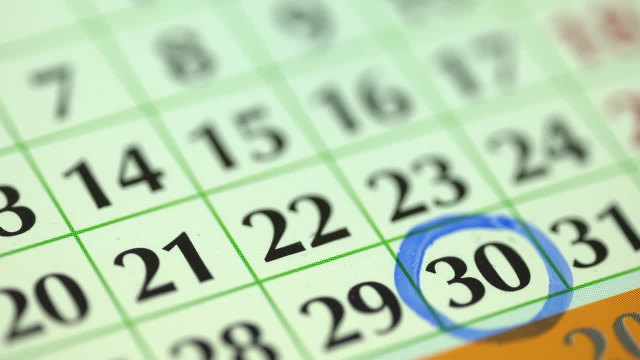 30o  trigésimo día del mes. la mujer marca la fecha del calendario con un marcador azul. planificador y organizador del calendario de la pared de negocios