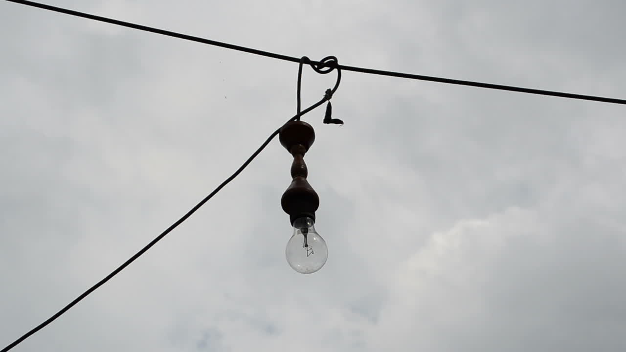Glødelampen mod himlen. Lampe på en ledning