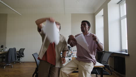 joyful office celebration: two colleagues throwing papers in the air