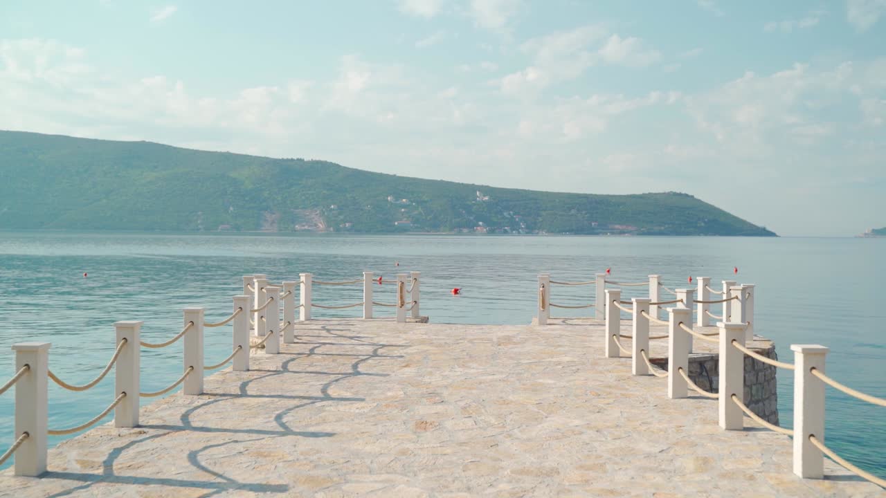 пов гуляет по пирсу и смотрит на море.