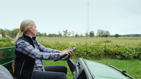 woman farmer rides a small grader on the field