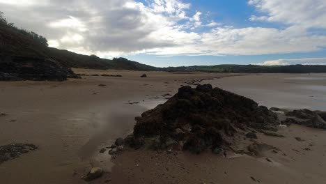 Zeitraffer-Schimmernder-Sonnenuntergang-Strand-Felsen-Pool-Wolken-Vorbeiziehen-über-Wald-Küstenlinie-Dolly-Rechts