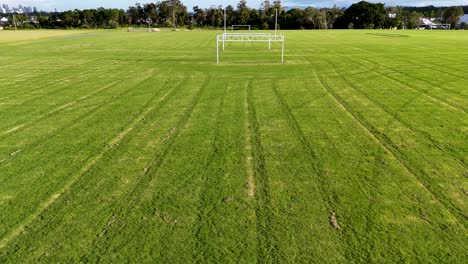 aerial view of a soccer field in gold coast, australia. the drone captures the field's green expanse and goalposts under clear skies