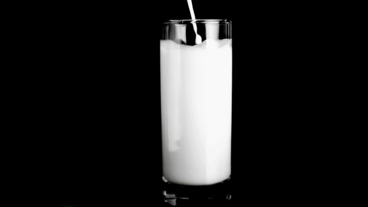Melk som helles i et glass i super sakte film