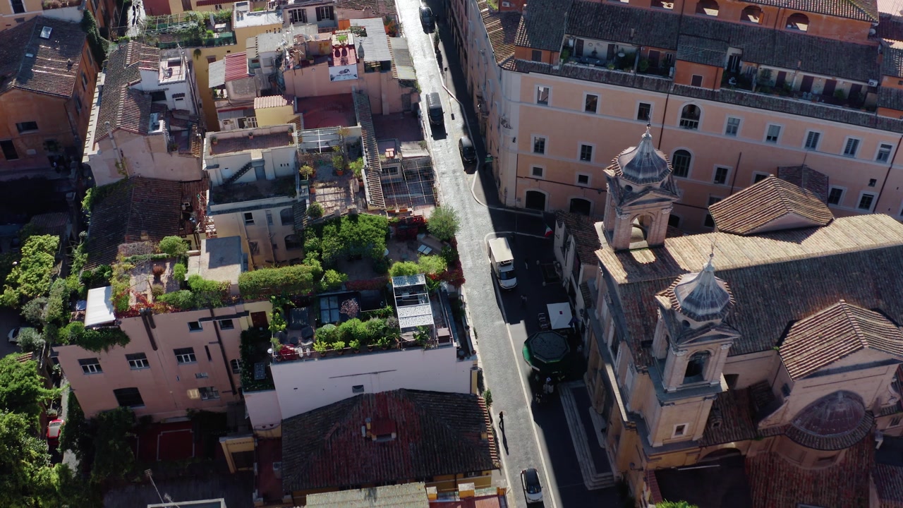 Aerial Drone View of Narrow Street in Rome Historic Center with Terracotta Rooftops, Old Apartment Buildings and Church Tower. Scenic Urban Architecture of UNESCO World Heritage Site in Eternal City.