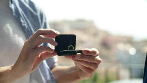 close-up shot of man holding box with engagement ring