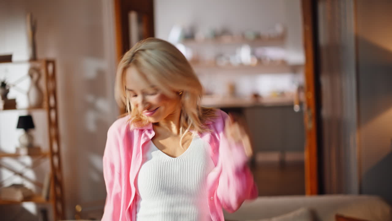 Carefree blonde dancing home closeup. Cheerful woman partying at sunny apartment