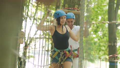 adventure climbing high wire park - people on course in mountain helmet and safety equipment