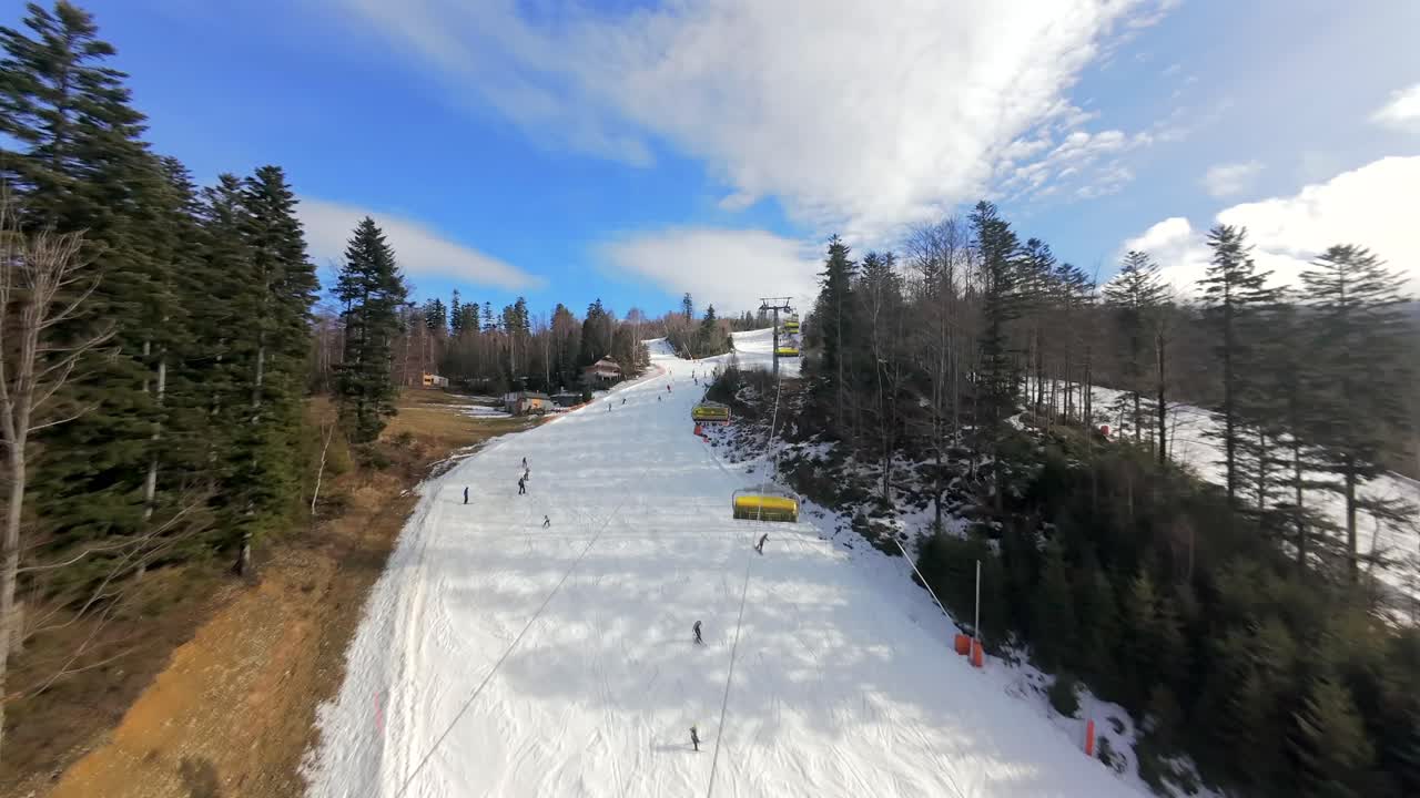Veduta mozzafiato da drone FPV del paesaggio invernale di Solisko a Szczyrk. Sciatori e snowboarder in azione.