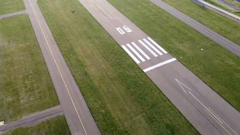 Landing-strip-of-an-airport-between-green-grass-on-a-sunny-day