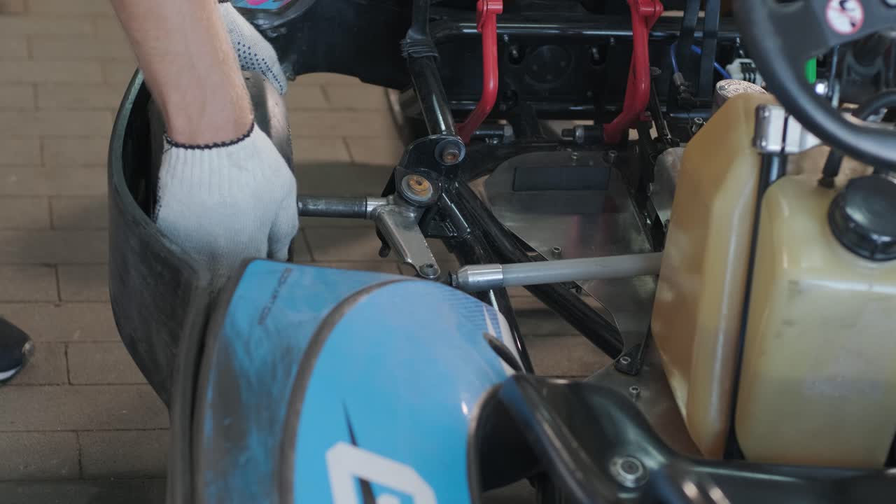 el mecánico del servicio de carreras de go kart cambia las ruedas
