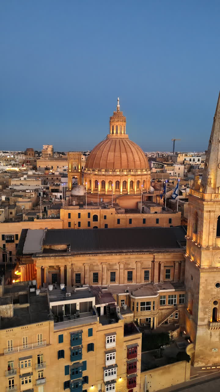 Aerial drone view of the walled city of Valletta, Malta, surrounded by the Mediterranean sea in the evening. Vertical
