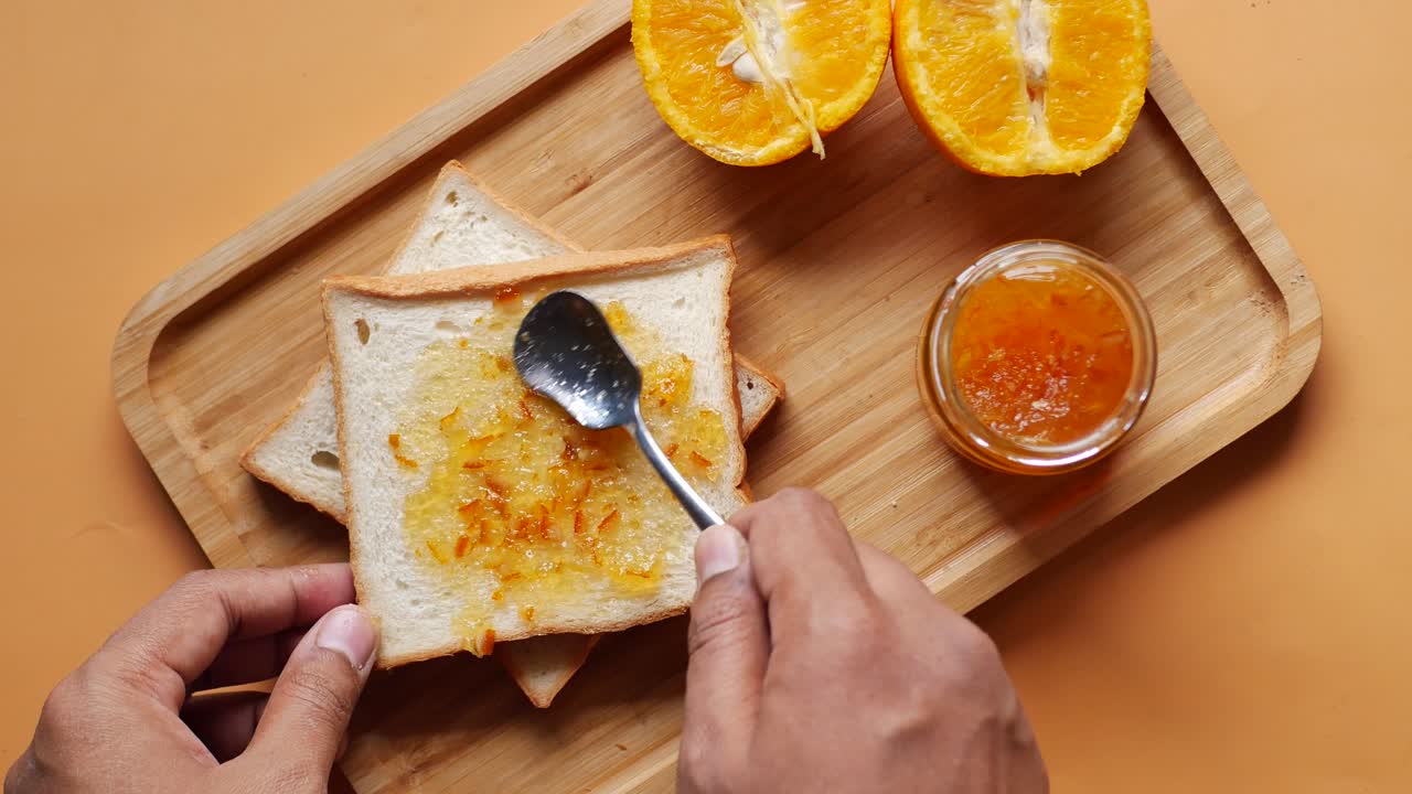 Orange fruit spread on a bread on table ,