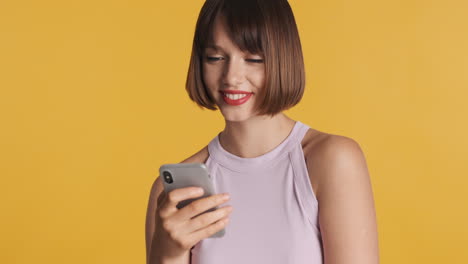 happy brunette woman with gray smartphone