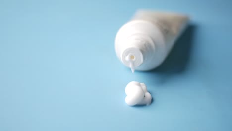 white cosmetic cream tube with a spill