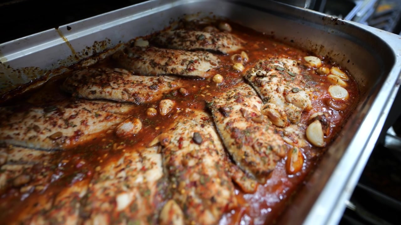 Primo piano di carne cotta rimossa dal forno in una fabbrica alimentare.