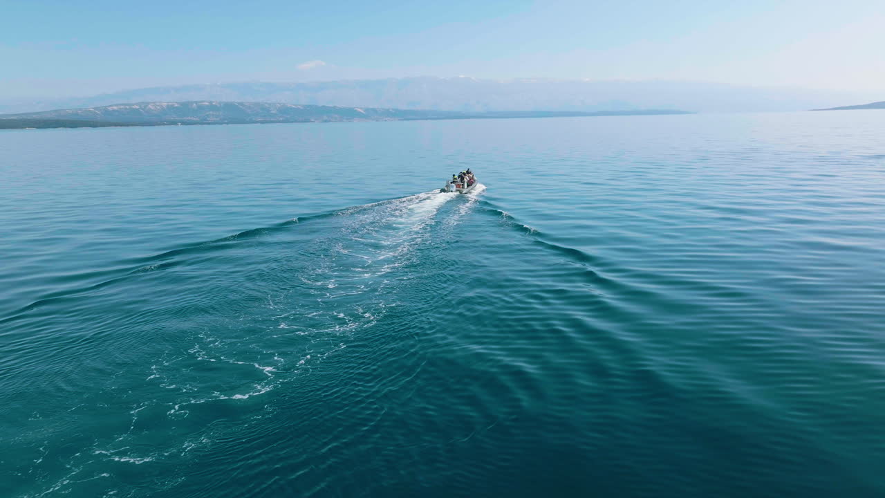 tour en barco navegando cerca de la isla de lošinj, en croacia, para realizar una actividad de observación de delfines.