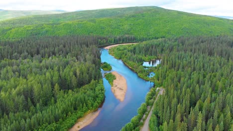 Video-De-Dron-De-4k-Del-Hermoso-Río-Chena-Mientras-Corre-A-Través-De-Montañas-Cubiertas-De-Pinos-Cerca-De-Las-Aguas-Termales-De-Chena,-Alaska-En-Verano