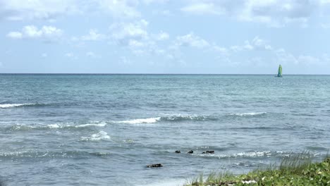 Sailboat-in-the-distance,-sailing-the-ocean-on-a-beautiful-day