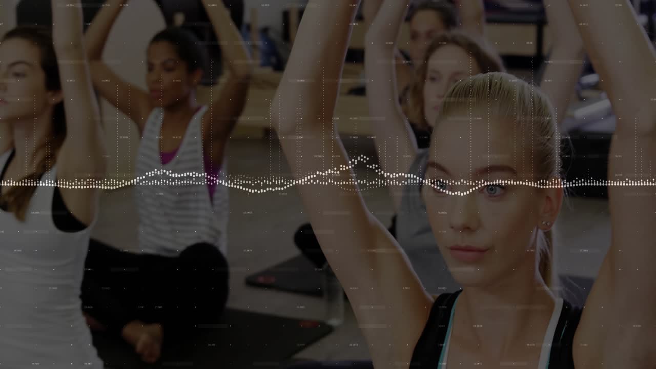 Offscreen instructor guiding women on mats stretching up forming heart shapes for yoga practice