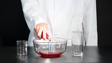 a scientist demonstrates a candle experiment creating a pressure difference to suck up water in a laboratory setting