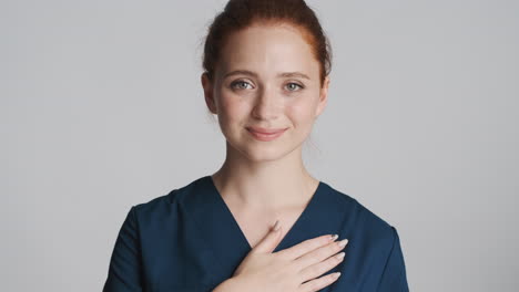 redheaded doctor in front of camera on gray background.