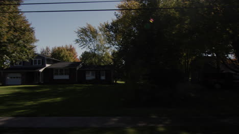 drive along a typical agricultural region in the u.s. the sun illuminates houses and fields