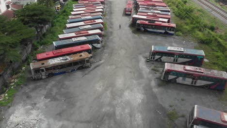 reveal shot of busses junkyard at kuala lumpur during a cloudy day, aerial