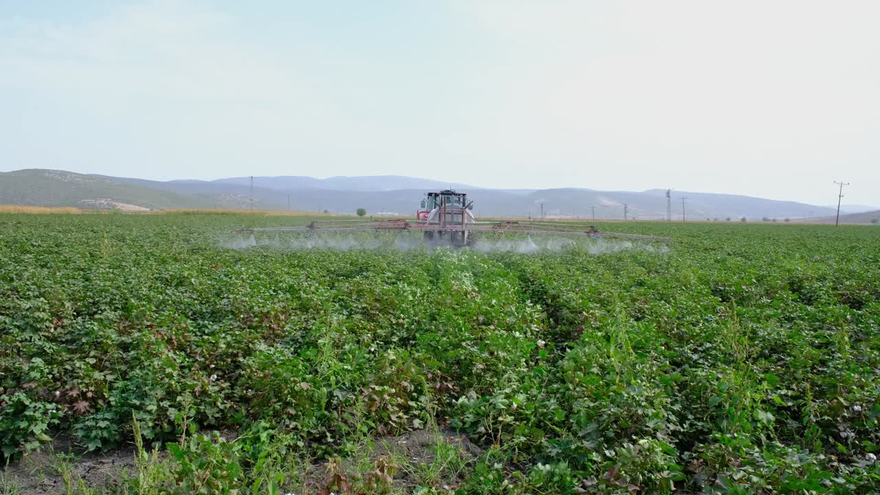 Trattore che irrora pesticidi su un campo agricolo.