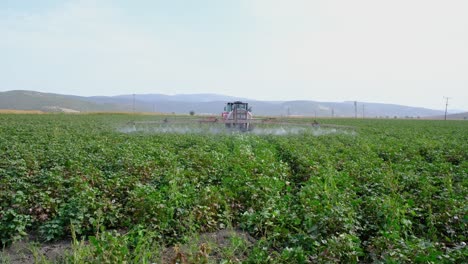 tractor rociando pesticidas en un campo agrícola