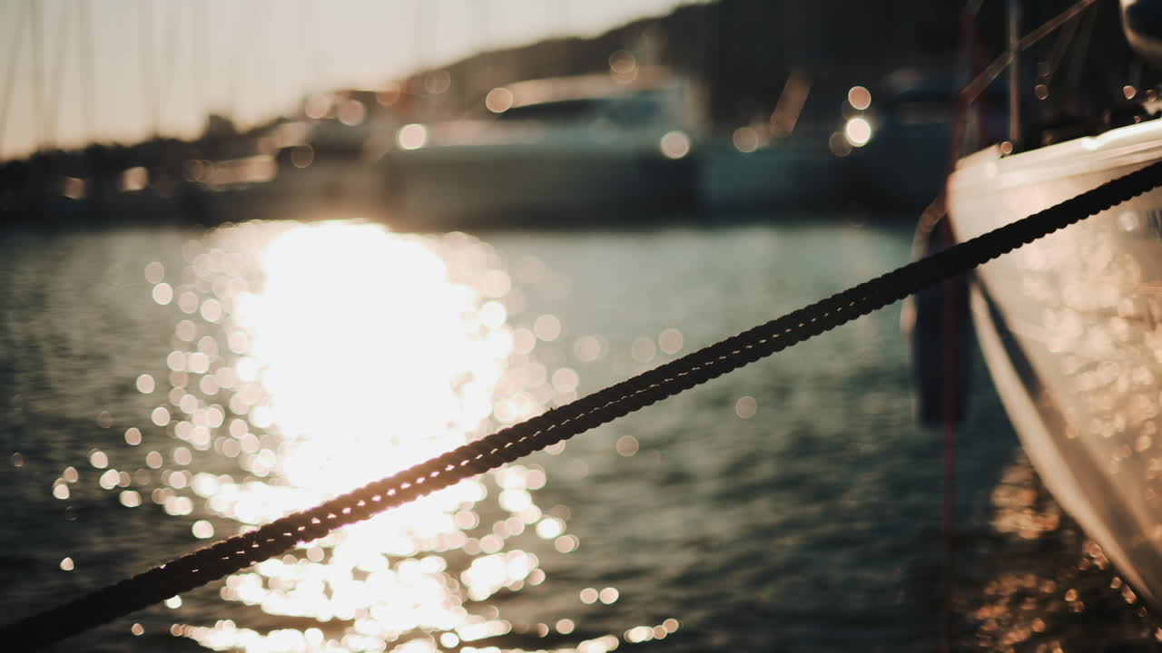 Golden sunlight shimmering on the side of a yacht floating on calm water