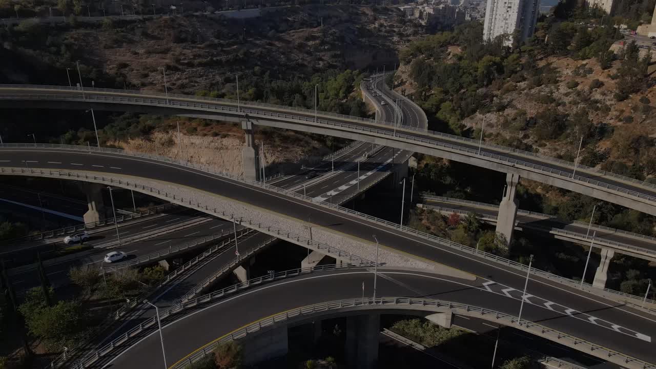 Revealing view of a series of roads and bends with passing cars, Haifa city in the background, Israel