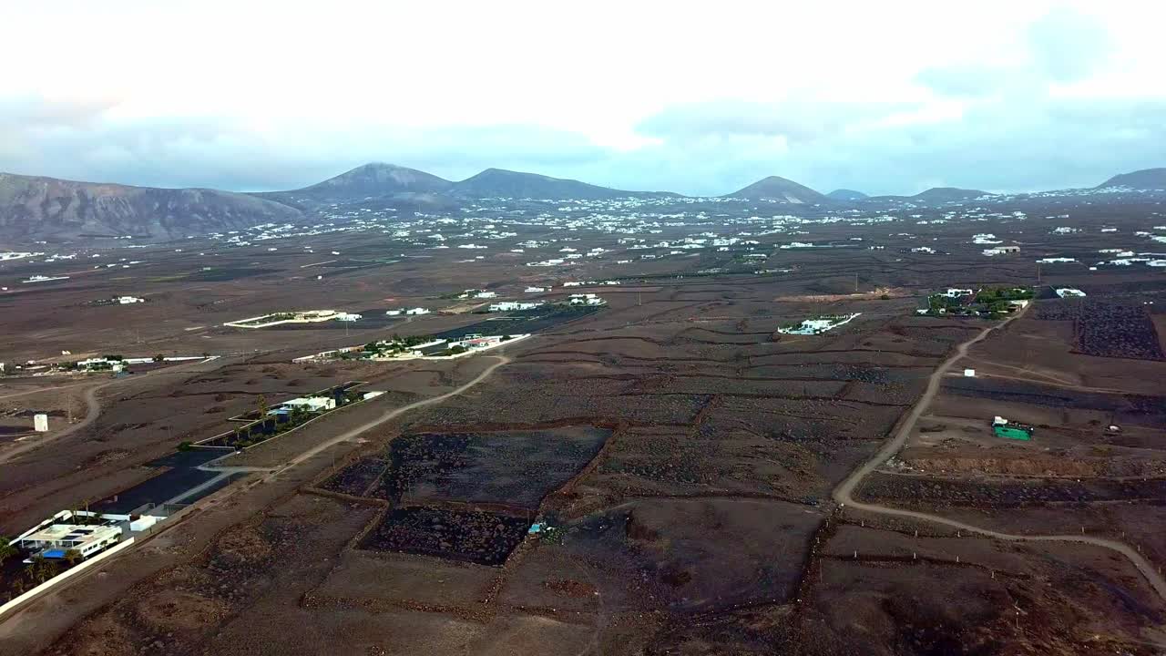 Drone shot facing Macher Lanzarote from Puerto Del Carmen cliff edge with mountains in the background