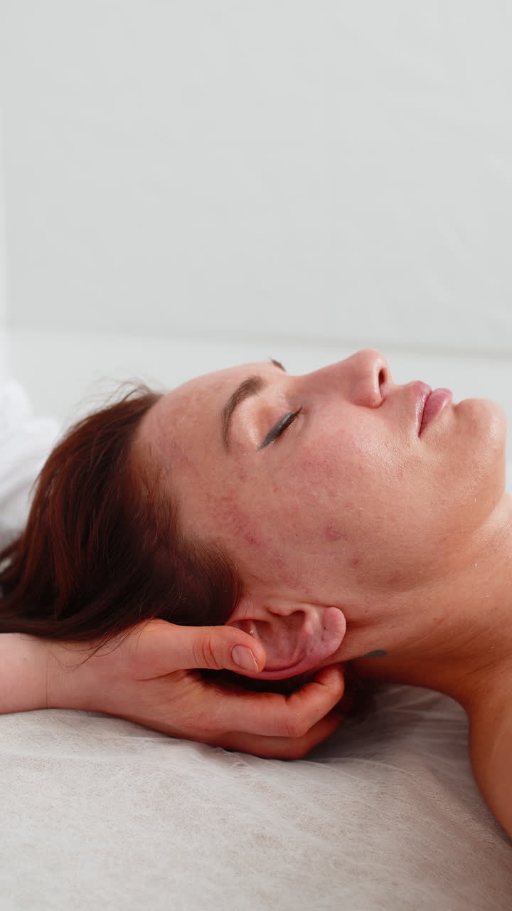 Woman receiving scalp massage in cosmetology clinic by beautician relaxing therapeutic procedure