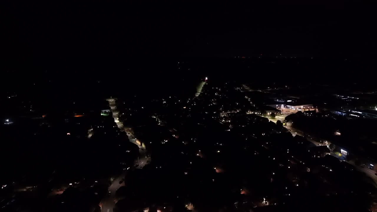 Quiet small American city with historic center squares and historic buildings lighting at night. Illuminated streets of neighborhoods in background. Drone forward wide shot