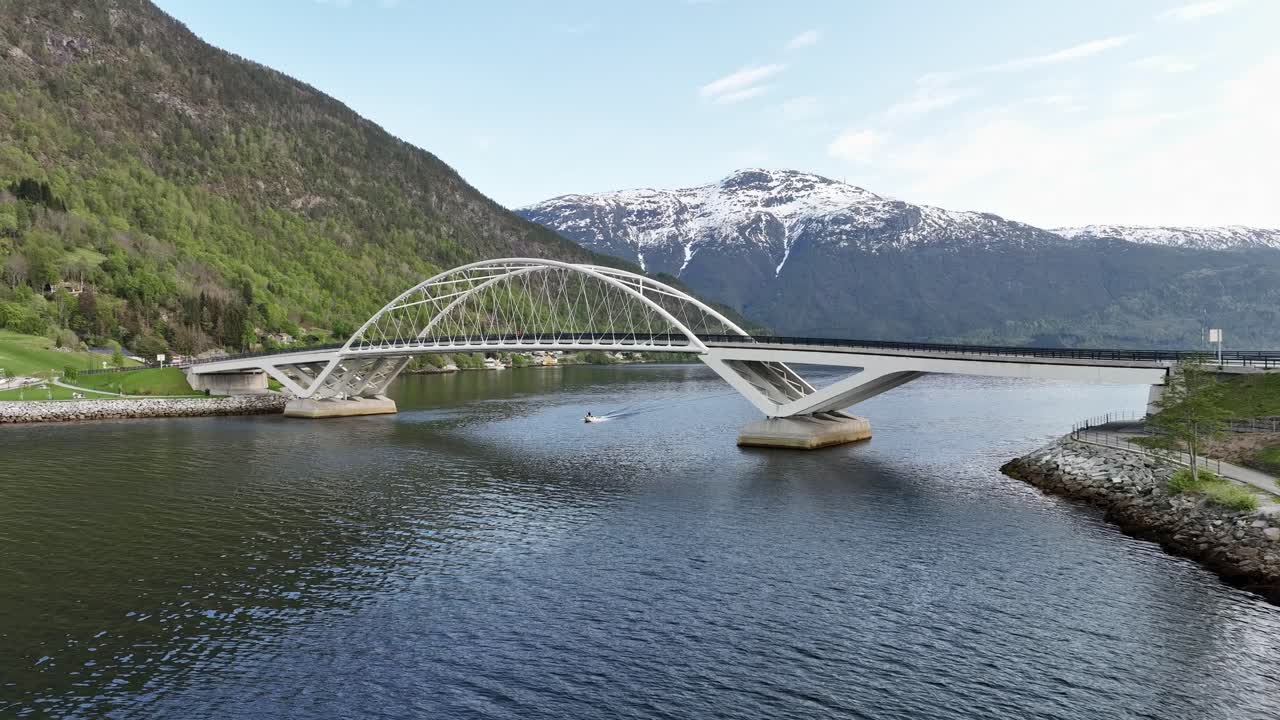 puente sogndal loftesnes visto con fondo de montaña y un pequeño barco que pasa por debajo - noruega a baja altitud aérea