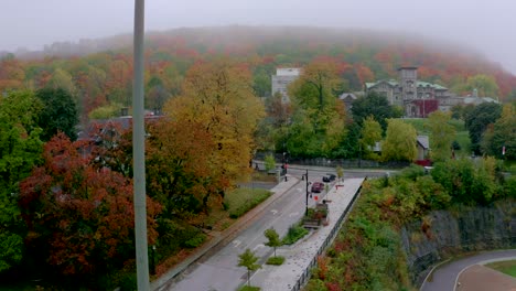 drone moving up on a light spot revealing the beautiful and colourful mount-royal in montreal on a foggy fall morning