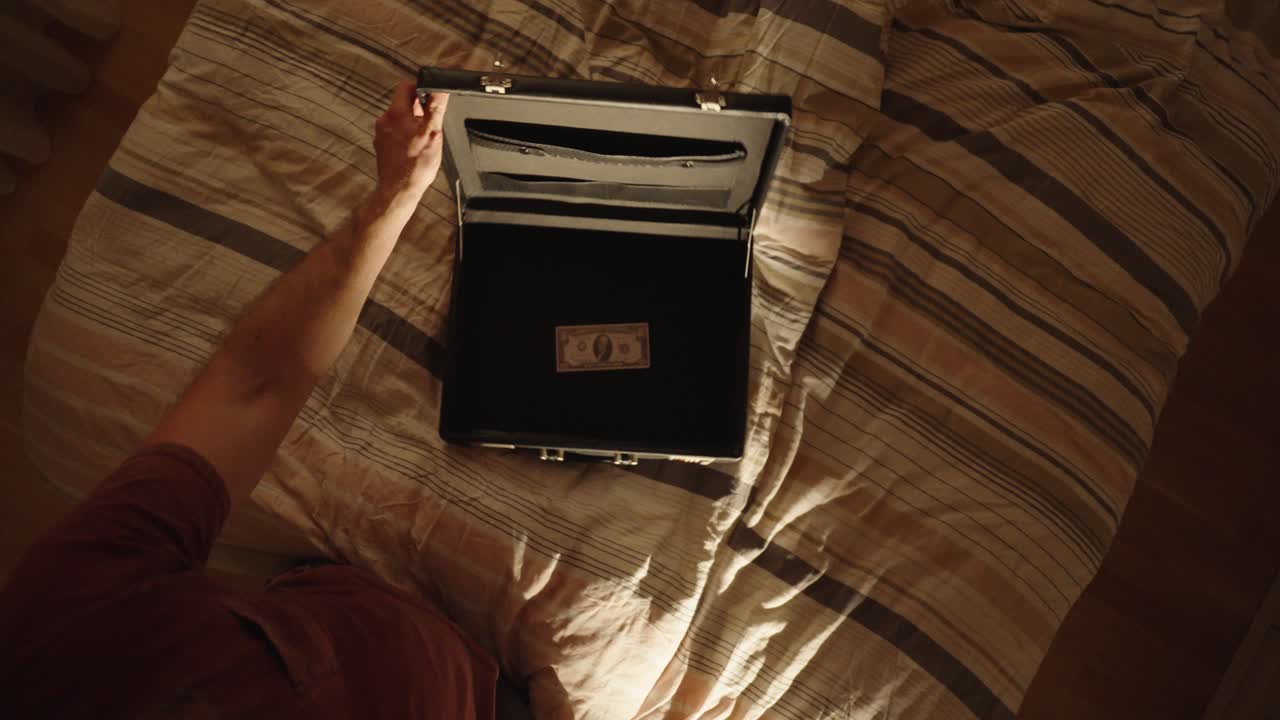 classic birefcase: a man opens a briefcase on the bed, filmed from above