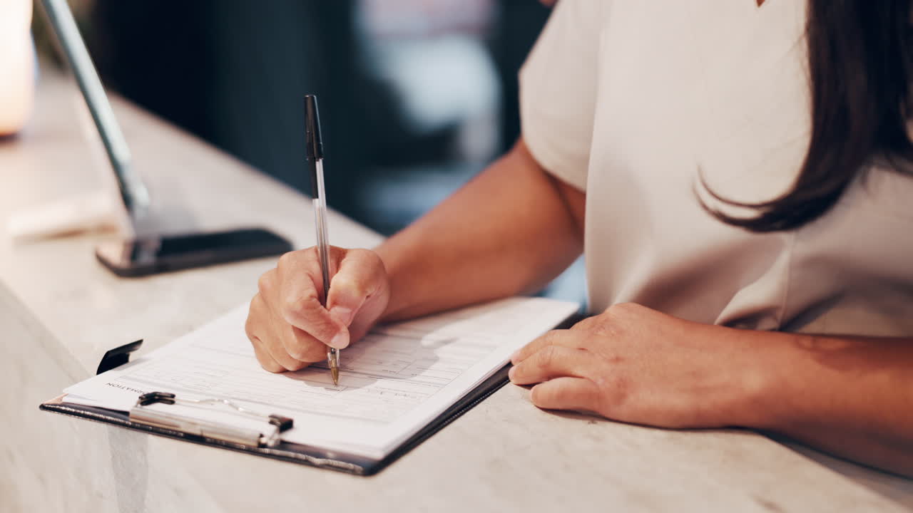 Close Up of a Person's Hand Filling Out a Form