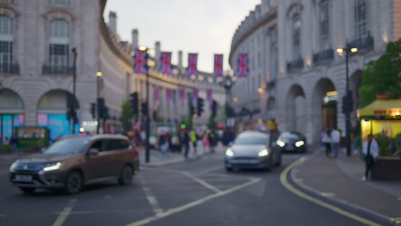 Blurred view of a crowded street near Piccadilly Circus with flags and traffic in London, England