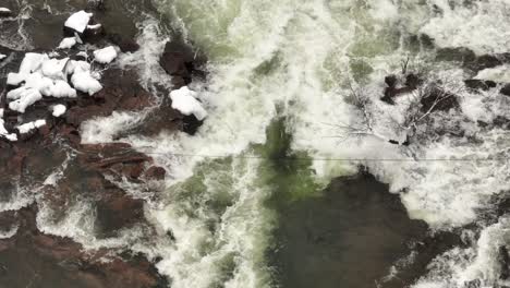 free flowing winter waterfall aerial view