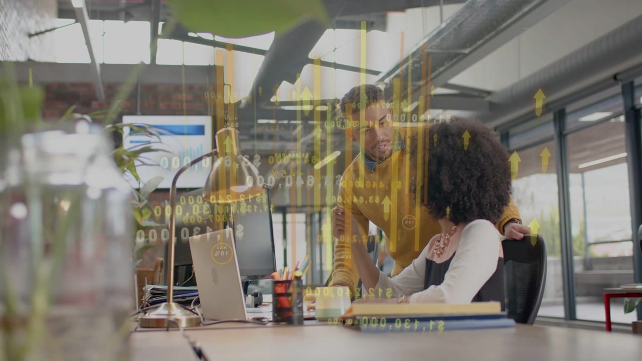 Man approaching her, business charts overlaying laptop, pointing, she following, reviewing metrics